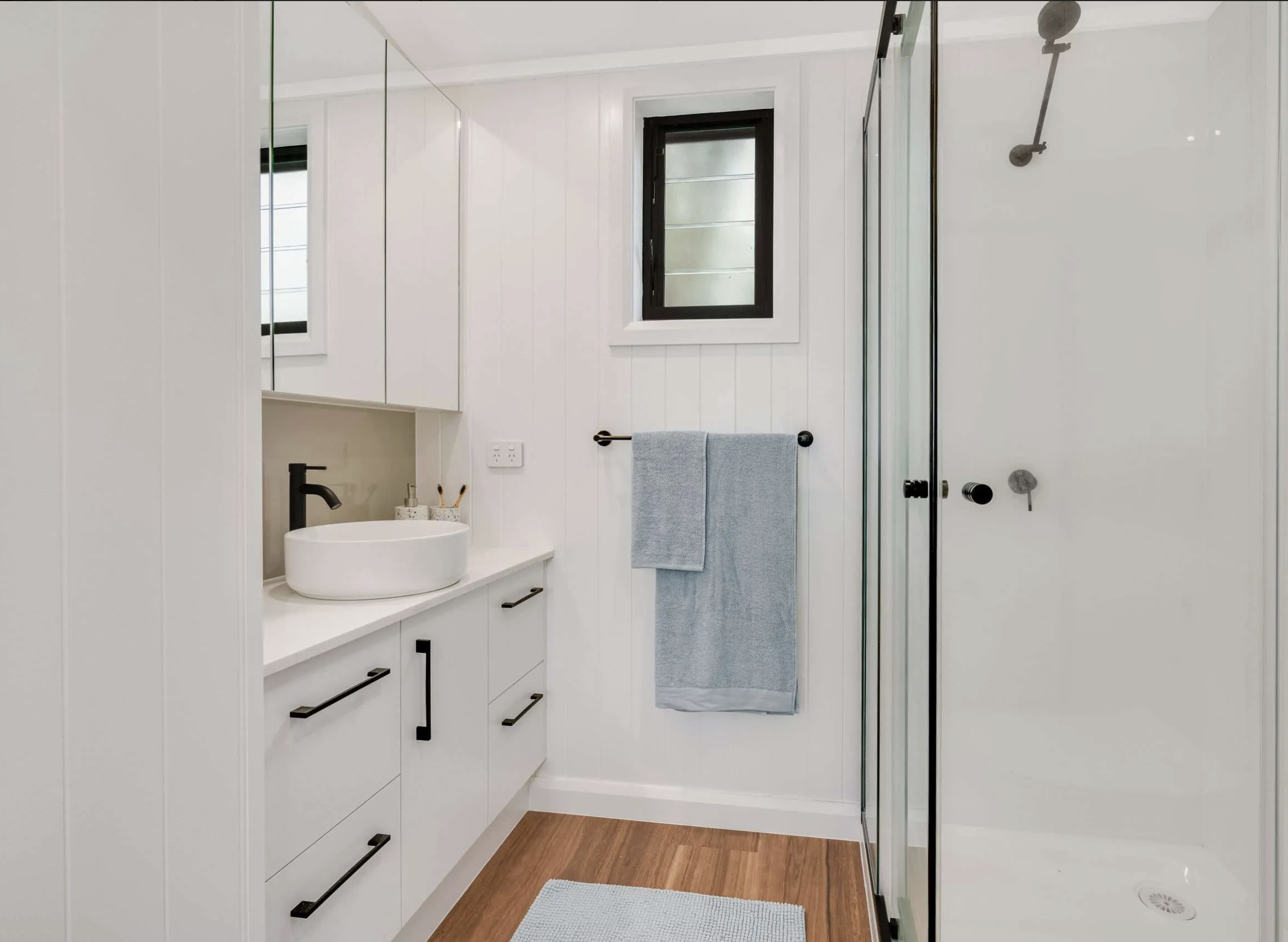 Tiny Home Central bathroom interior with vanity, towel rail and shower